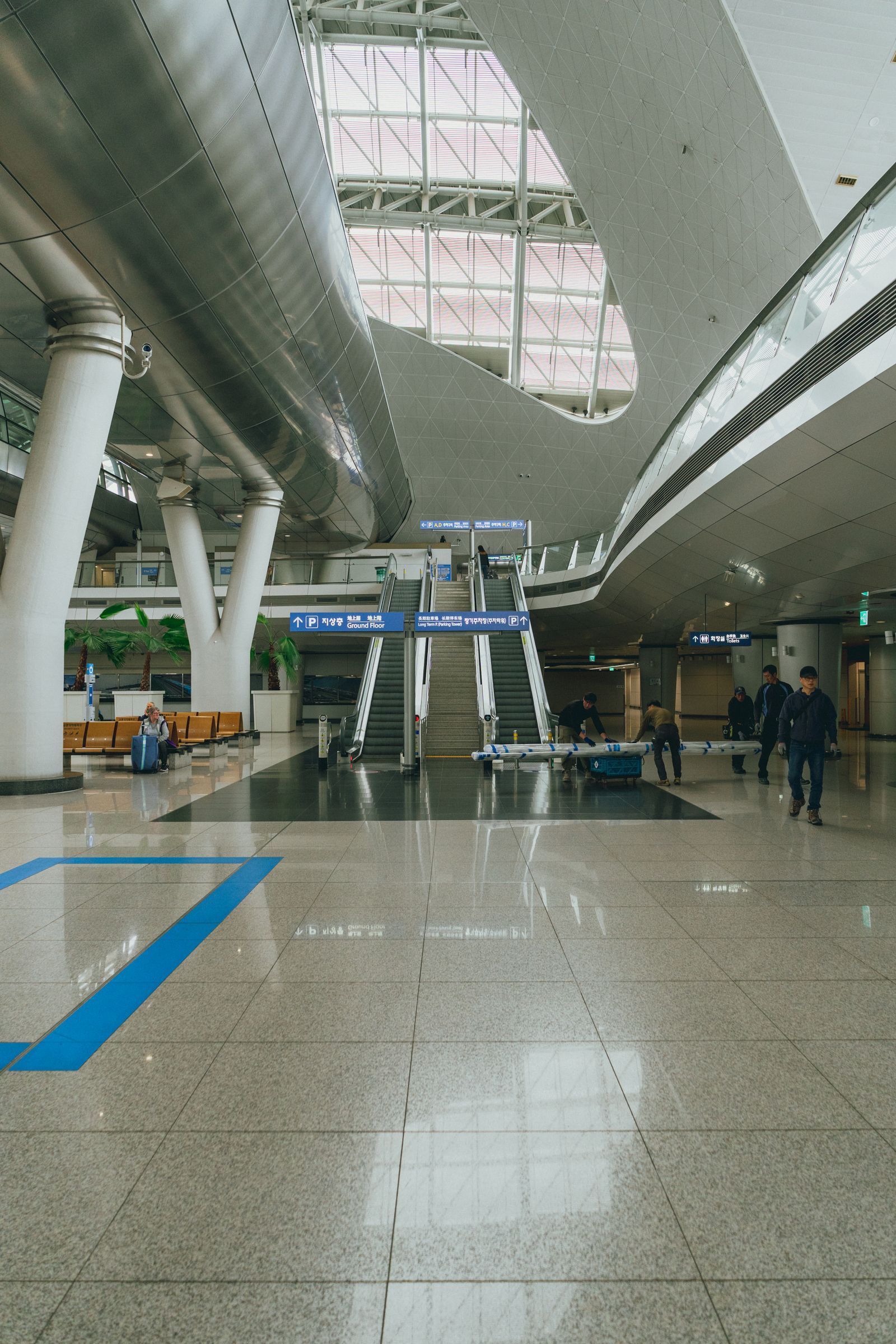 Wide interior of Incheon International Airport with travellers and escalators